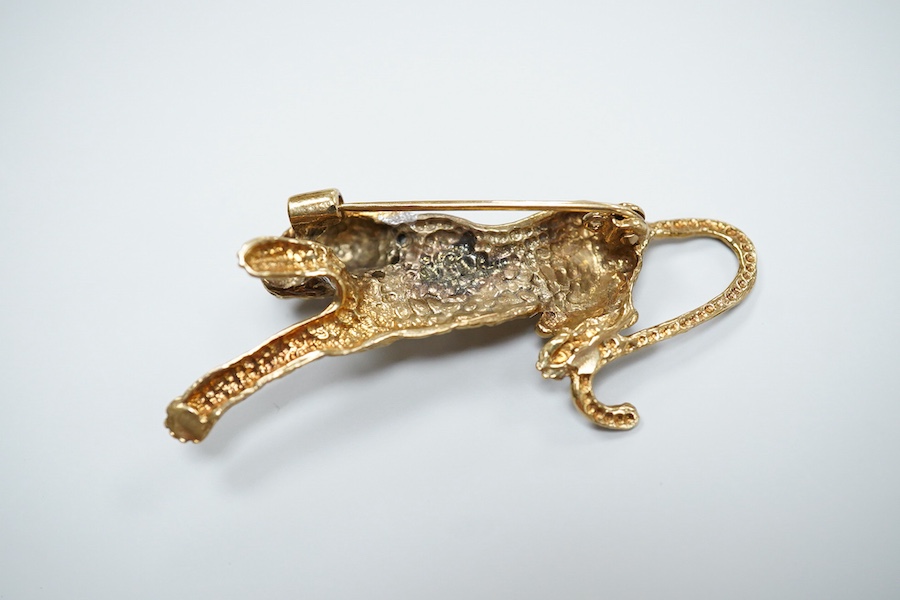 Two 9ct gold brooches, one designed as a collared leopard, its eyes set with rubies, length 5.2cm; the other designed as a hummingbird in flight, its eye set with an emerald, length 4.9cm, each in textured 9ct gold, Brit